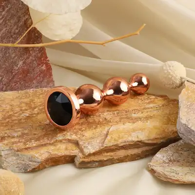 Gender X - Gold Digger M. Średni, elegancki i stylowy. Metalowa wtyczka analna w kolorze rose gold z czarnym klejnotem w podstawie. 