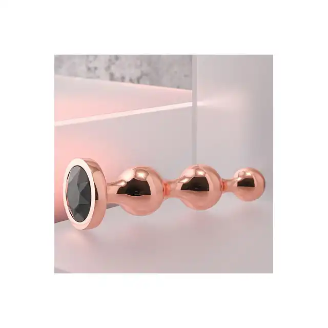 Gender X - Gold Digger M. Średni, elegancki i stylowy. Metalowa wtyczka analna w kolorze rose gold z czarnym klejnotem w podstawie. 