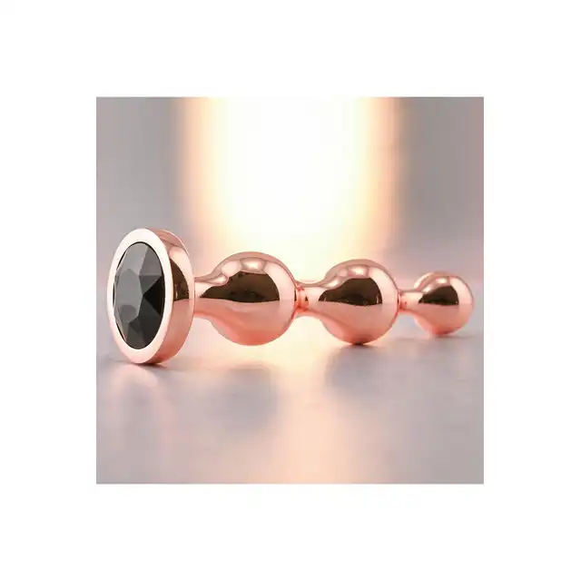 Gender X - Gold Digger M. Średni, elegancki i stylowy. Metalowa wtyczka analna w kolorze rose gold z czarnym klejnotem w podstawie. 