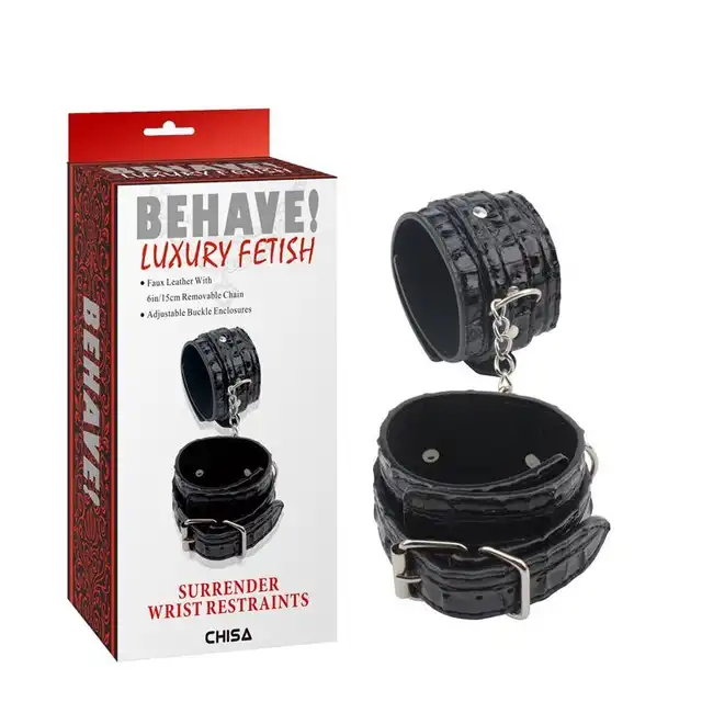 Behave! - Surrender Wrist Restraints. Czarne, wytrzymałe kajdanki z regulacją rozmiaru. Mocno połyskujący materiał
