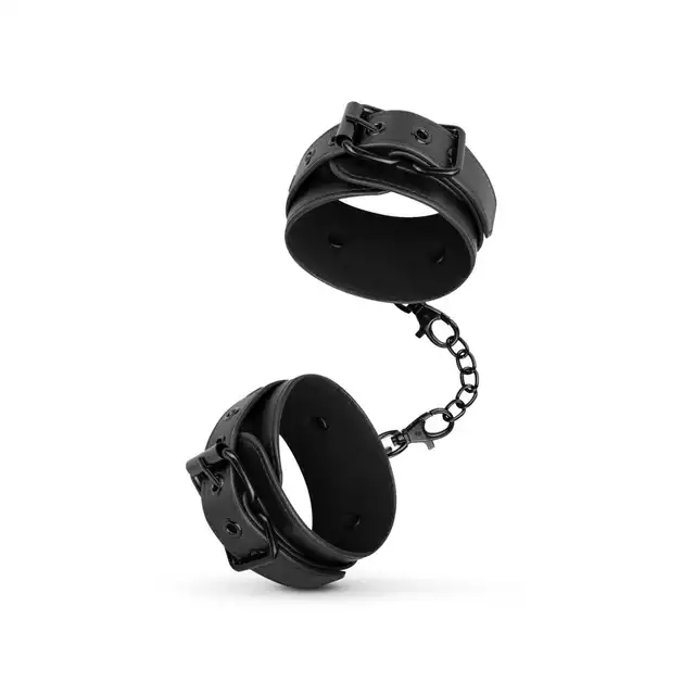 Bedroom Fantasies - Handcuffs One Size. Regulowane kajdanki na nadgarstki w klasycznej połyskującej czerni, z wegańskiej syntetycznej skóry